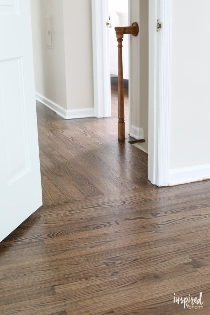 an empty room with hard wood floors and white trim on the walls, in front of a door