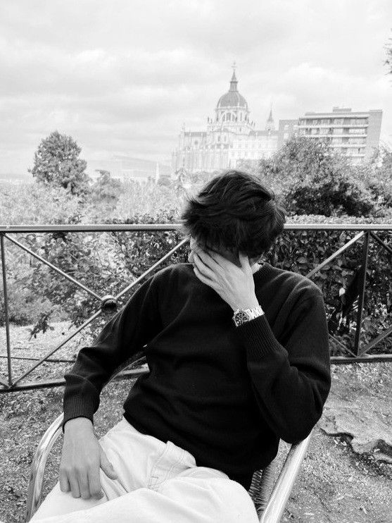 a man sitting on top of a metal bench