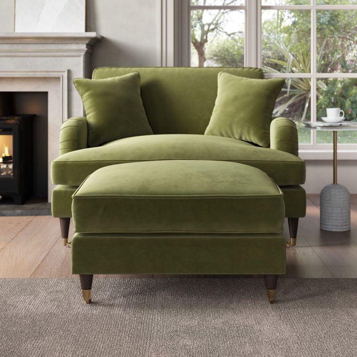 a green chair and ottoman in front of a window with a fire place behind it