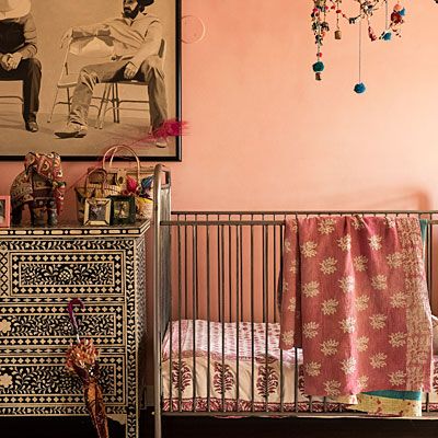 a baby crib in front of a pink wall