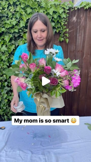 a woman holding a bouquet of flowers in front of a screen with the text, my mom is so smart