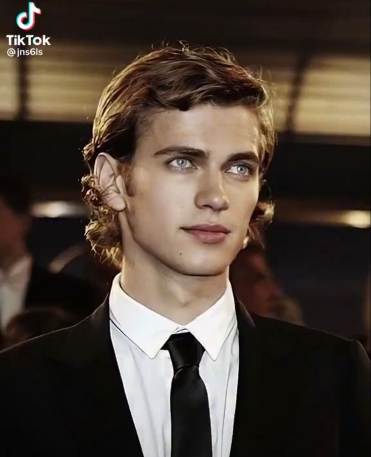 a young man in a suit and tie looking at the camera with an intense look on his face