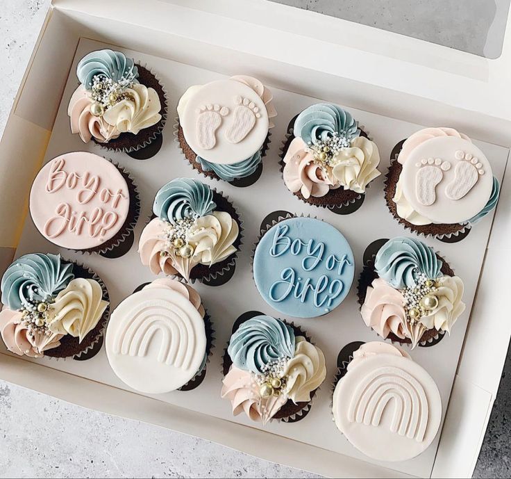 twelve cupcakes in a box with baby's first names and footprints on them