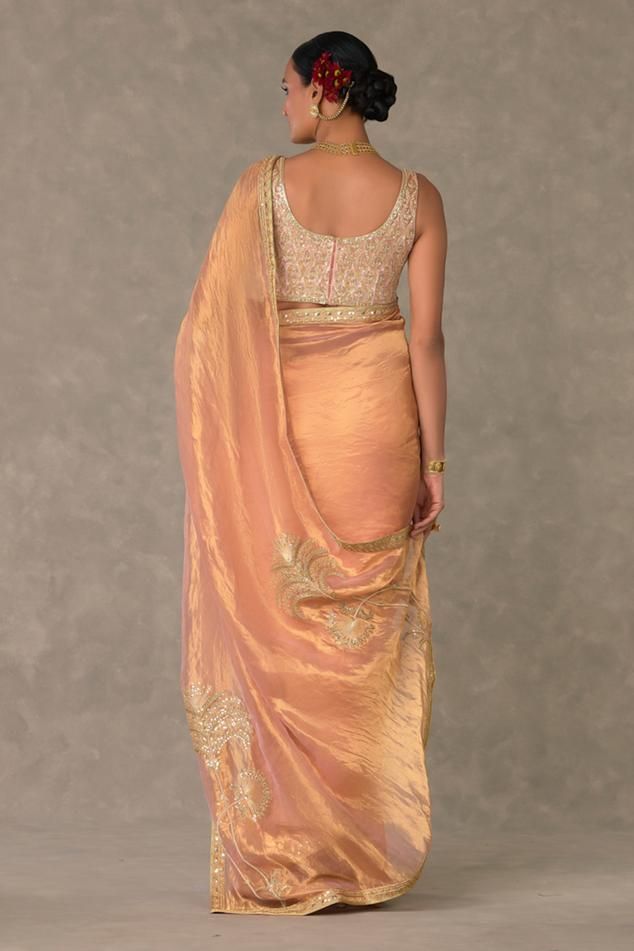 Peach saree crafted in tissue base with kalpatru motif embroidery using dori, sitara and moti work, accentuated with an embroidered border. Comes along with an unstitched blouse piece with jaal embroidery in pita and dori work. 
Components: 2
Pattern: Embroidery
Type Of Work: Kalpatru, Moti, Sitara, Dori
Fabric: Saree - Tissue, Blouse piece - Velvet  
Color: Peach
Other Details: 

Note: The stitched blouse worn by the model is not for sale
Disclaimer: The actual print-placement and colour of the Shahi Tukda, Brocade Saree, Peach Saree, Tissue Saree, Embroidered Border, Blouse Design Models, Velvet Color, Blouse Fabric, Embroidered Blouse