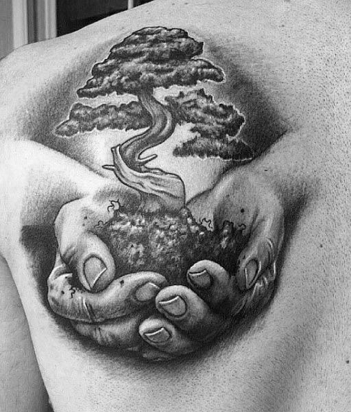 a man's chest with an image of a tree in his hands