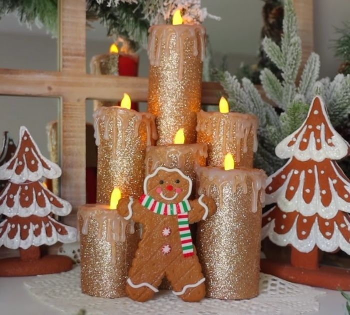 a group of candles that are sitting in front of some christmas trees and gingerbreads