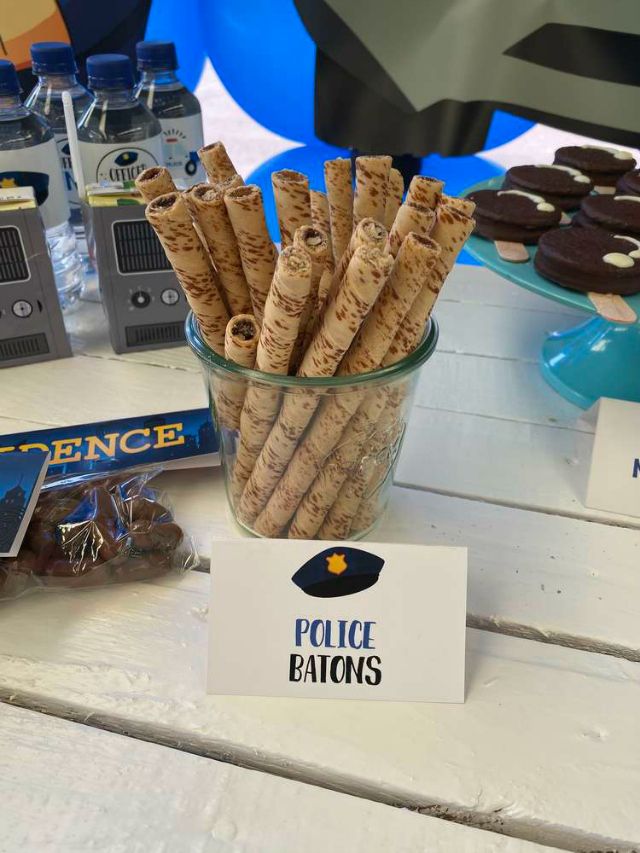 a police officer themed party with cookies and snacks on the table, including chocolate covered pretzels