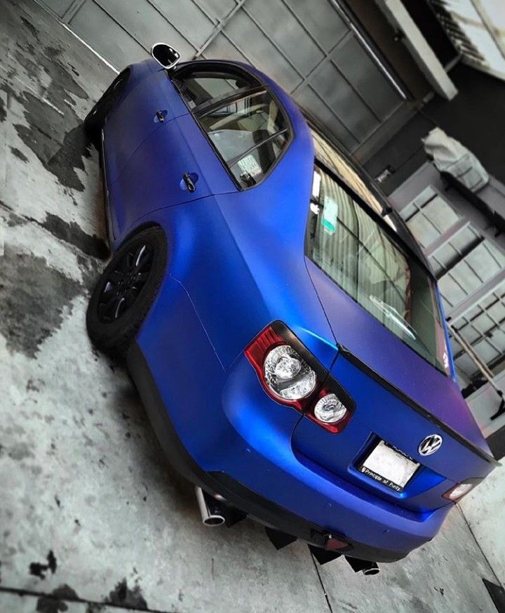 the rear end of a blue car parked in a garage