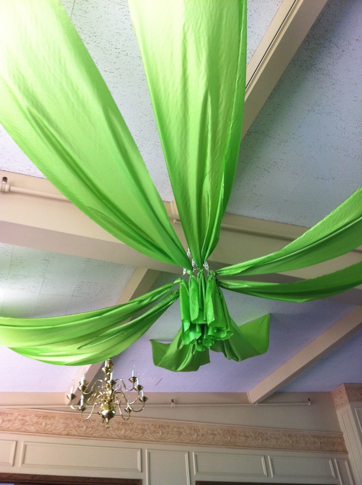 the ceiling is decorated with green fabric and chandelier