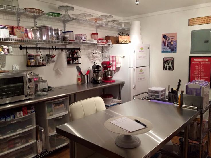 a kitchen with stainless steel counter tops and shelving on the wall, along with shelves filled with items