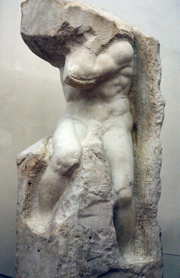 a statue of a man holding a rock in his right hand and leaning on it's back