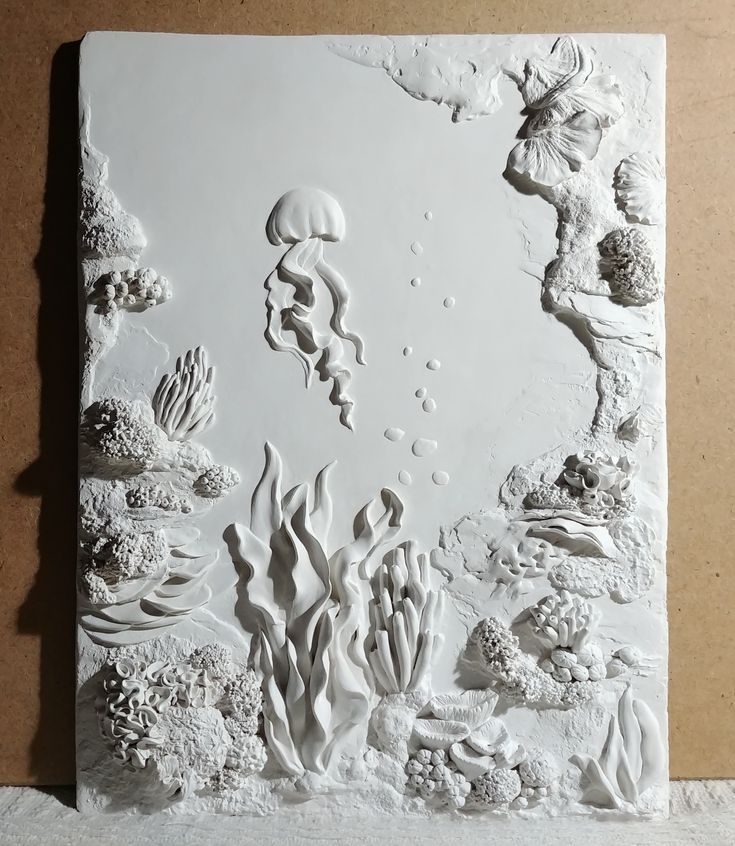 an art work is displayed on the wall in front of a piece of paper that has been cut out to look like corals