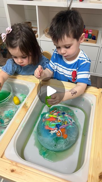 two children are playing with toys in the kitchen