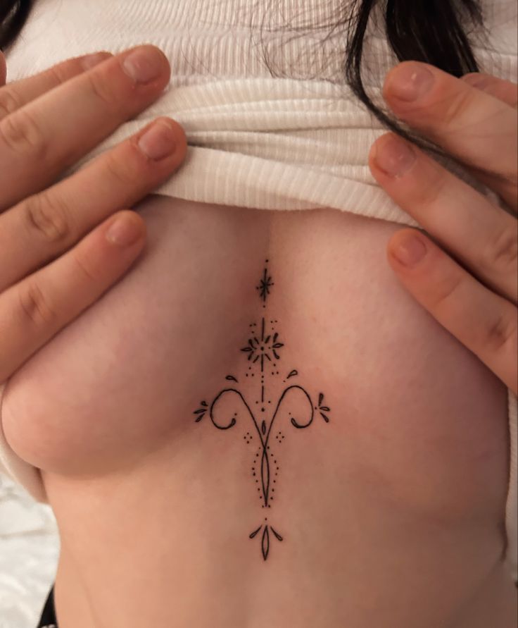 a close up of a person with a tattoo on her stomach and hand behind her back