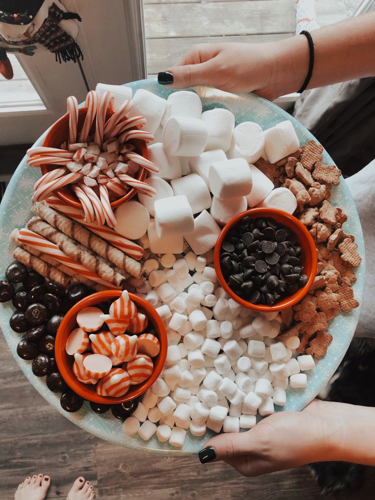 a plate filled with marshmallows, pretzels, and other snacks