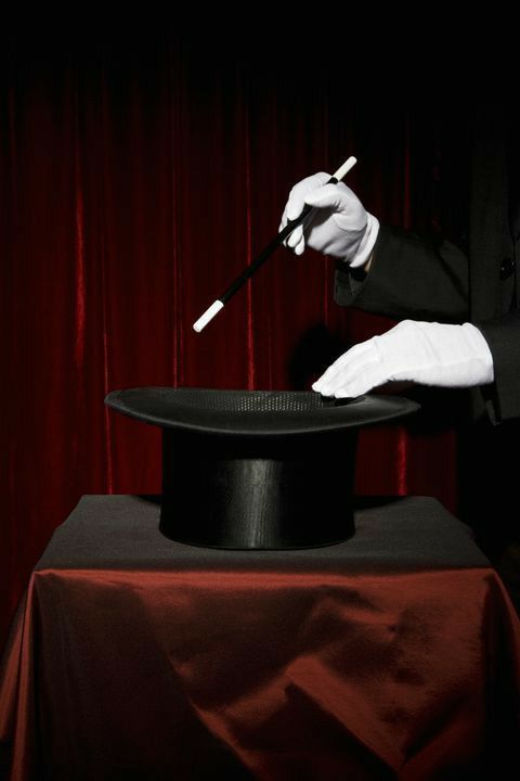 a man in a tuxedo holding a knife and pointing to a top hat