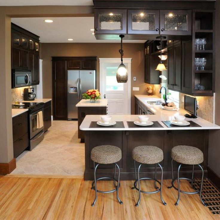 a kitchen with wooden floors and black cabinets