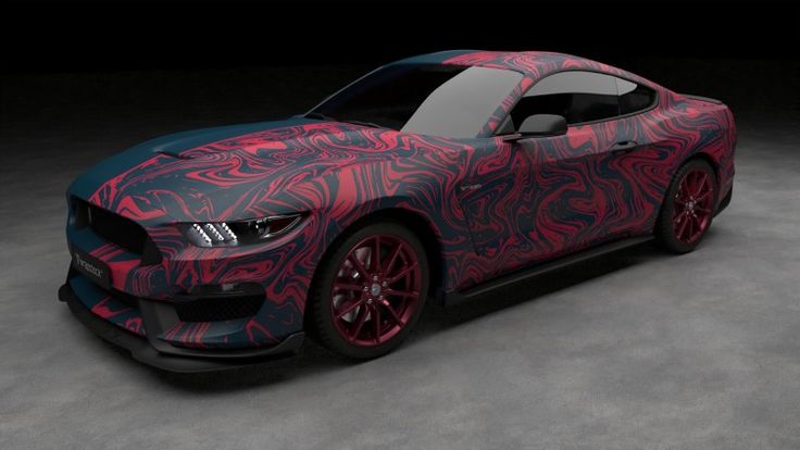 a red and black car with designs on it's hood, parked in a dark room