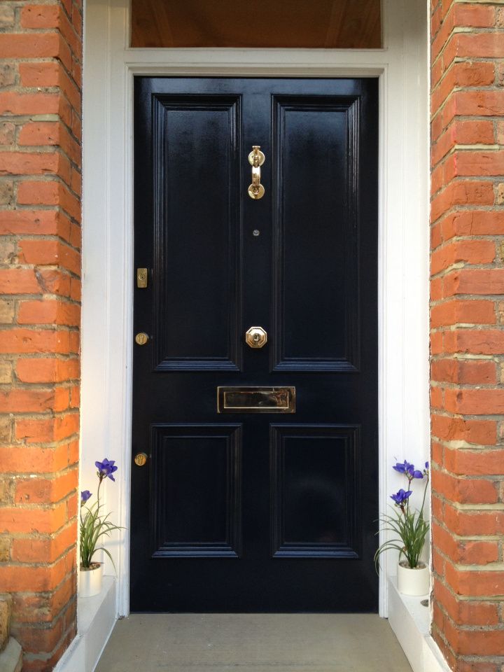 a black front door with two planters on either side