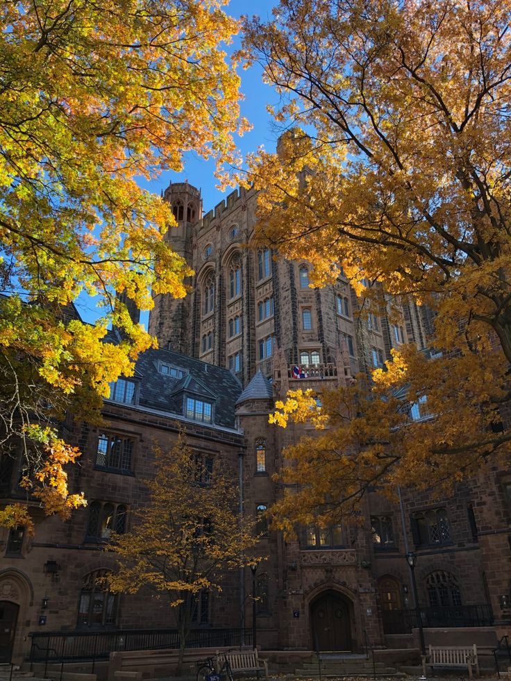 an old building surrounded by trees with yellow leaves