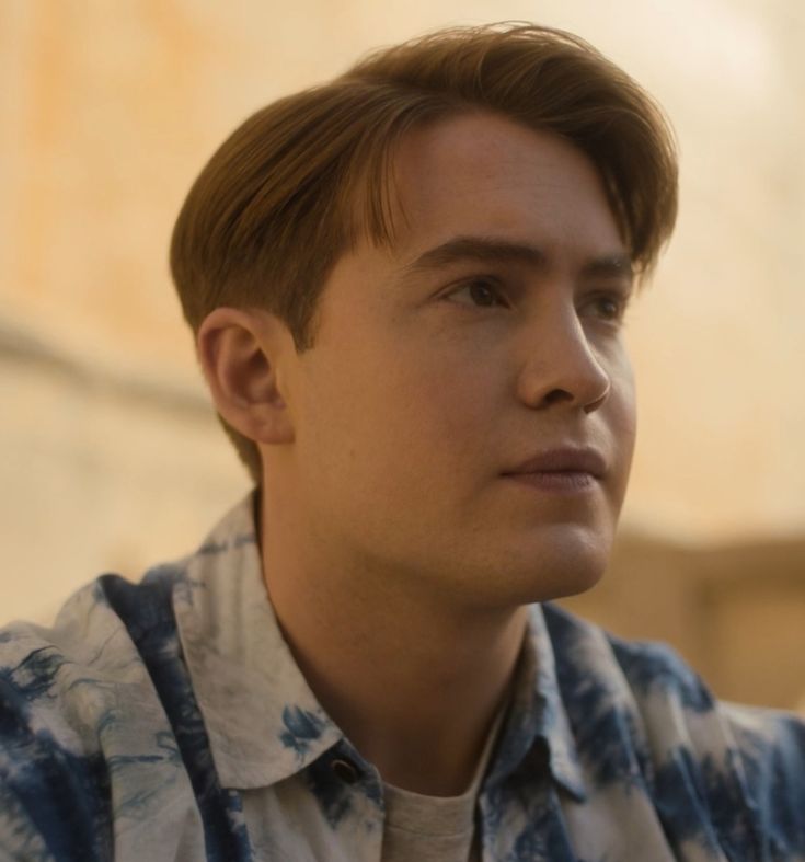 a close up of a person wearing a tie dye shirt and looking off to the side