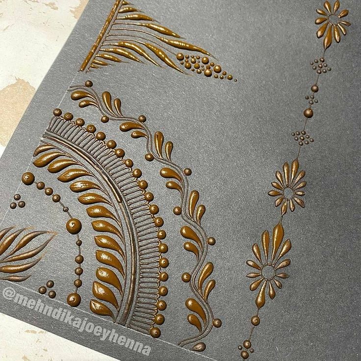 some gold and silver paper with designs on it