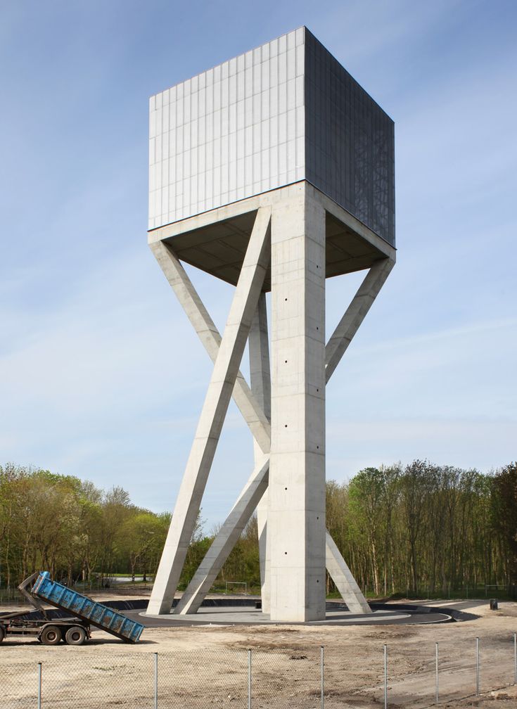 a tall white tower sitting on top of a dirt field