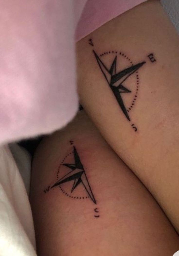 two tattoos on the legs of people with compasss and arrows tattooed on their thighs