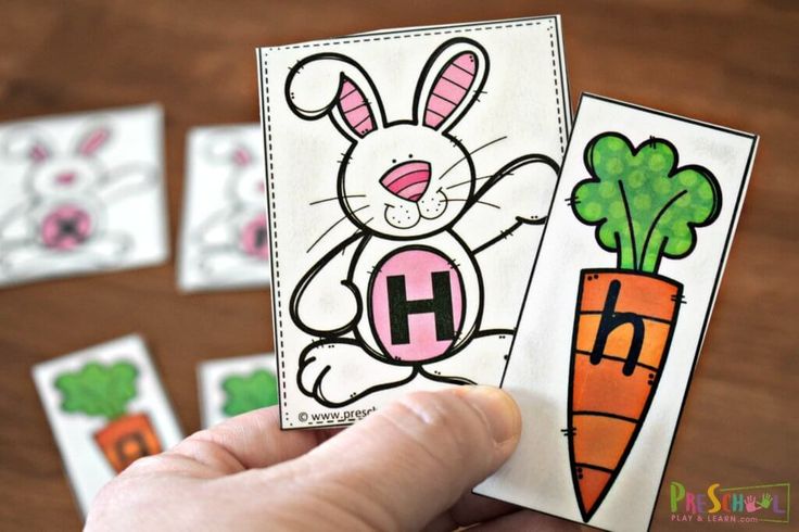 a hand holding up two cards with carrots and bunny on them