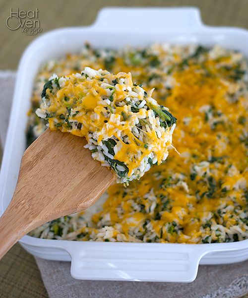 a casserole dish with spinach and cheese being scooped from the casserole