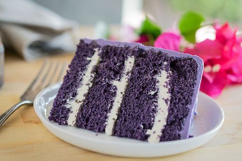 a slice of purple cake sitting on top of a white plate