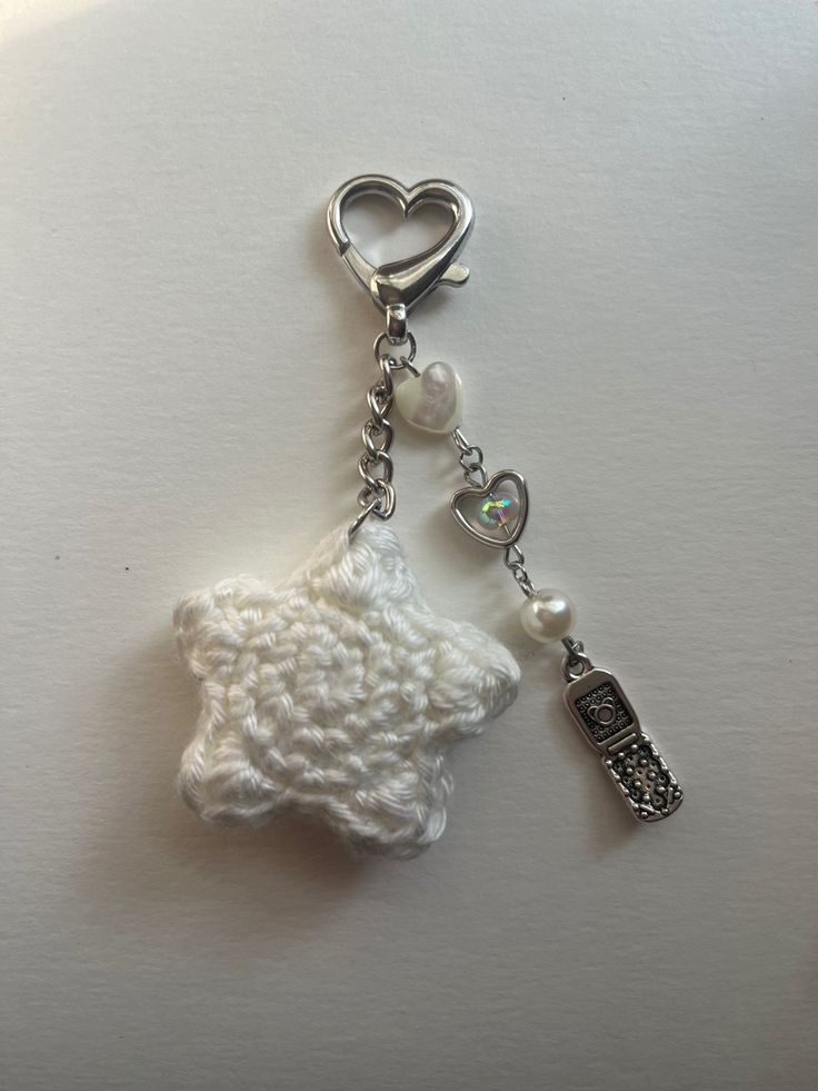 a keychain with a sheep charm attached to it's side on a white surface