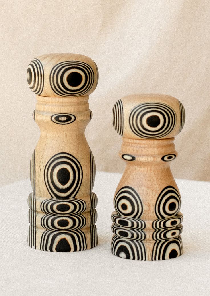 two wooden salt and pepper shakers on a white surface