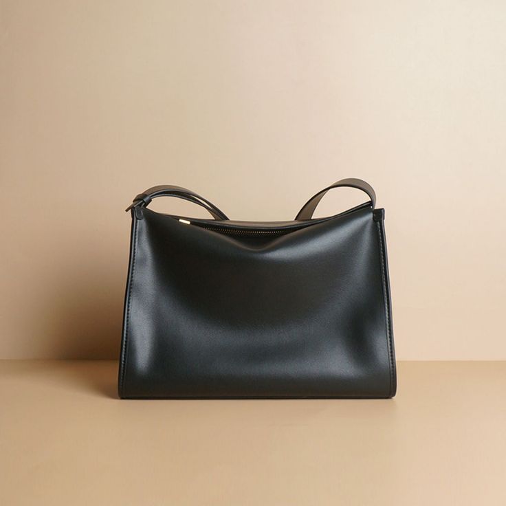 A relatively simple shaped leather shoulder bag. Vintage gold metal fittings and zippers create an elegant atmosphere. Made of soft cowhide leather, it feels good to the touch. There is a pocket inside. 
 
 
 Color 
 
 Black 
 Brown 
 
 
 Size 
 
 Height: 21cm 
 Width: 31cm 
 gusset: 13cm 
 Rise: 35-48cm 
 
 
 Material 
 
 Cowhide Sleek Satchel Shoulder Bag With Gold-tone Hardware, Sleek Business Shoulder Bag With Gold-tone Hardware, Formal Shoulder Bag With Large Capacity, Sleek Shoulder Bag With Gold-tone Hardware And Double Handle, Minimalist Soft Leather Evening Shoulder Bag, Elegant Shoulder Bag In Solid Color With Soft Leather, Sleek Leather Shoulder Bag With Smooth Grain, Minimalist Leather Bag With Gold-tone Hardware, Elegant Solid Color Shoulder Bag With Soft Leather