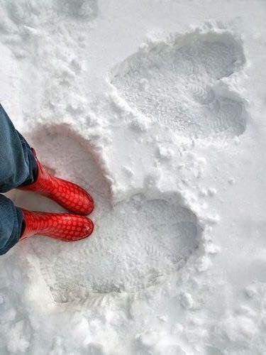 a person with red socks and boots standing in the snow