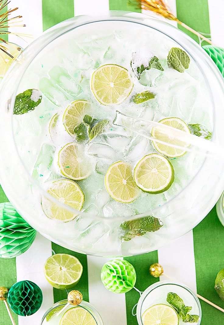 lemons, mint and limeade in glasses on a green and white striped tablecloth