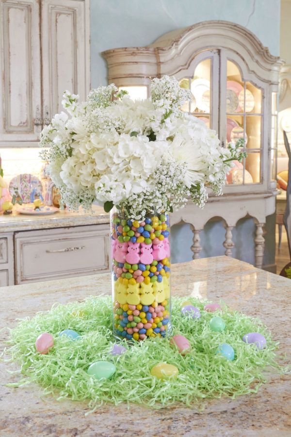 a vase filled with candy and flowers on top of a table