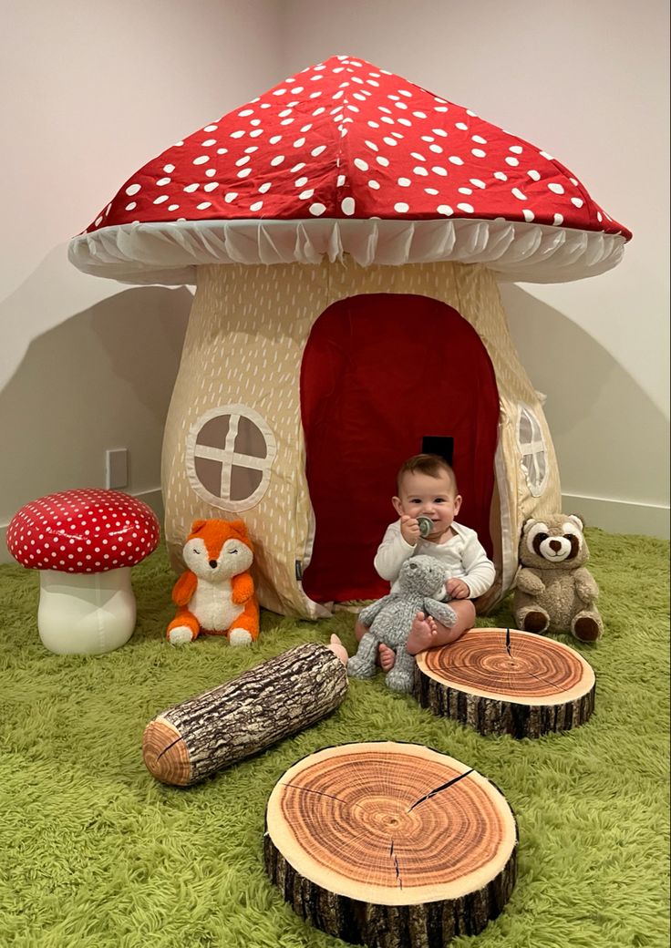 a baby sitting in front of a mushroom house