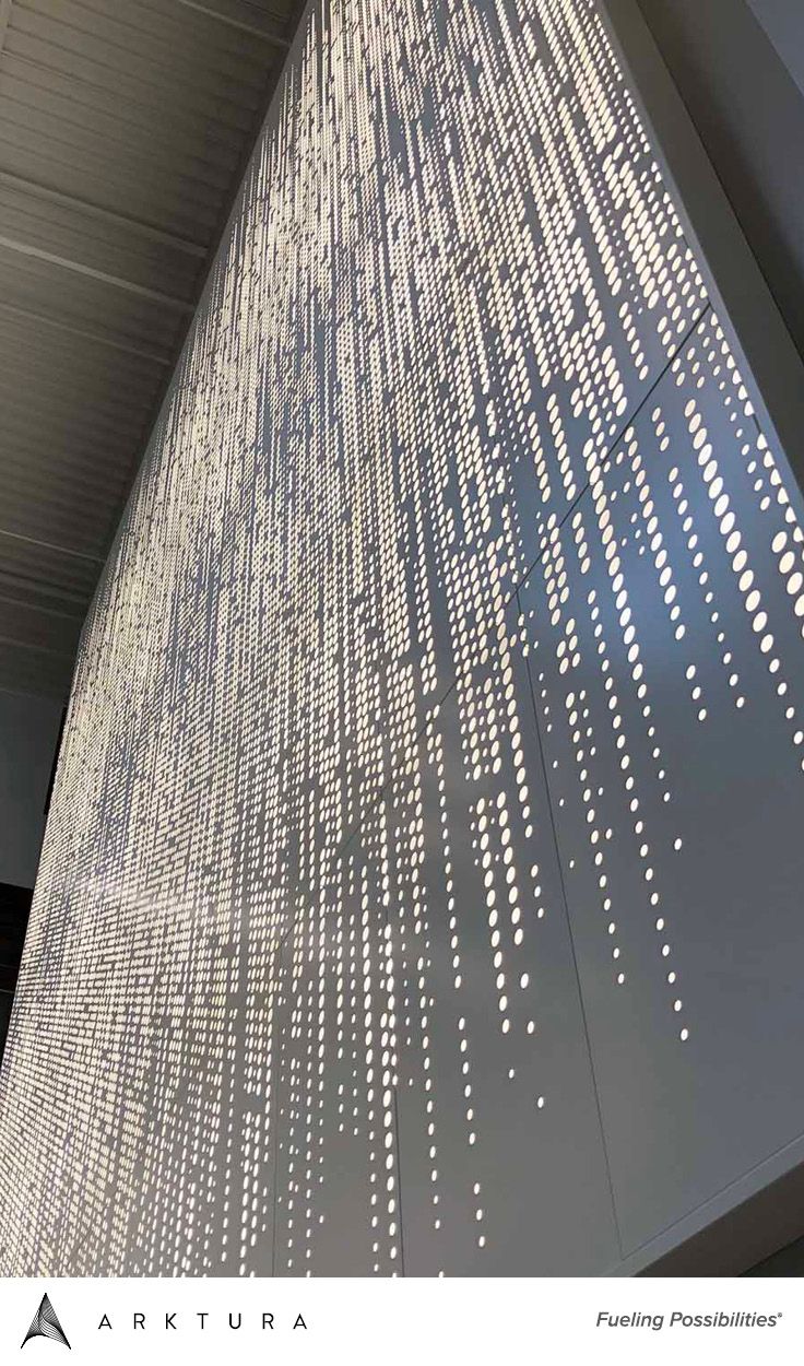 an artistic light fixture hanging from the side of a building with white dots on it