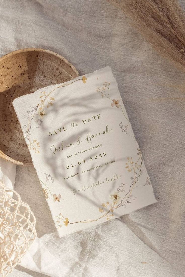 a wedding save - the - date card on a lace doily next to a basket