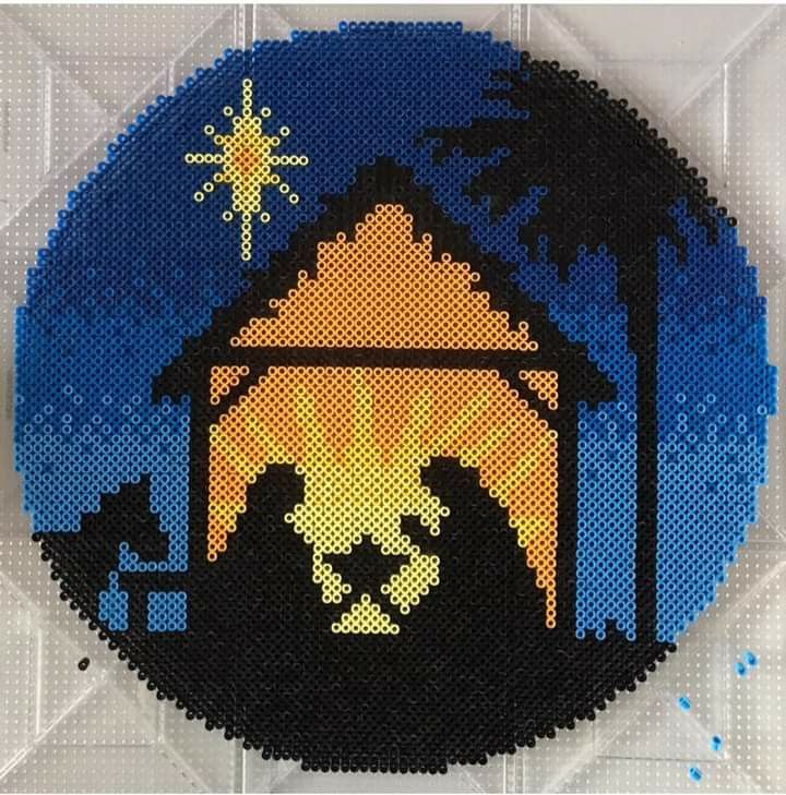 a cross stitch nativity ornament depicting the birth of jesus and baby jesus