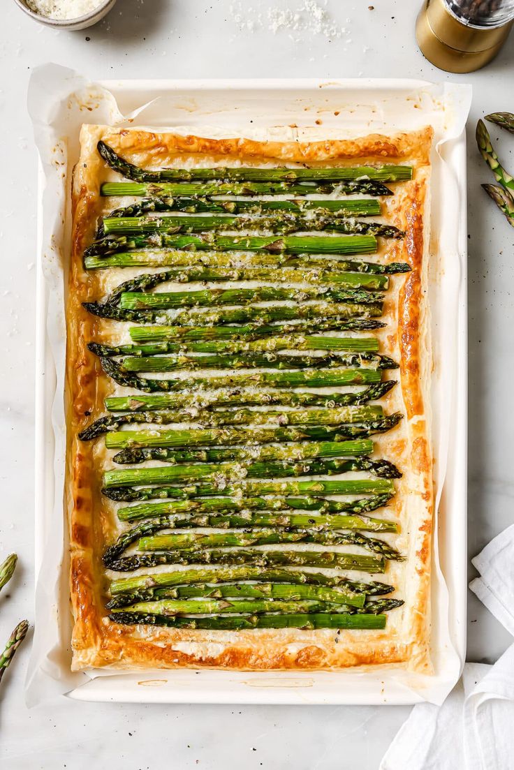 asparagus and parmesan quiche in a baking dish on a white surface