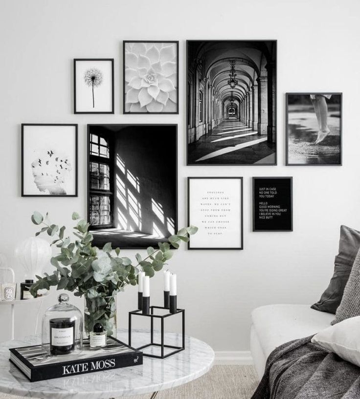 black and white photographs hang on the wall above a coffee table in a living room