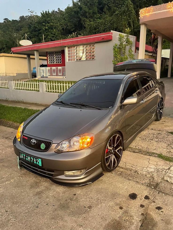 a silver car parked in front of a house