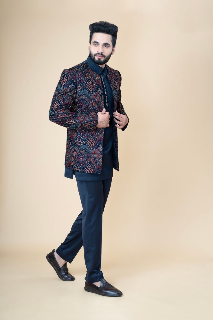 Festivities begin with  in the most fantastic ways. Festive Nocturne blue Bandi Jacket in handloom TR suiting fabric paired with a matching jacket, and trouser pants. The jacket is crafted in a mandarin collar with cut sleeves, and front button closure. The matching kurta comes in an asymmetrical sleeveless in a mandarin collar style. Elevate the look by pairing the outfit with some classic mules. Buttons and Accessories may vary in color, shape and size. WASH CARE INSTRUCTIONS - Please dry clea Tailored Blue Bandhgala For Festive Occasions, Blue Semi-formal Festive Unstitched Suit, Fitted Blue Bandhgala For Groom, Semi-formal Notch Lapel Bandhgala For Festive Occasions, Semi-formal Festive Bandhgala With Notch Lapel, Blue Long Sleeve Bandhgala For Groom, Blue Fitted Sherwani For Semi-formal Occasions, Blue Long Sleeve Unstitched Suit For Reception, Blue Long Sleeve Bandhgala For Semi-formal Occasions