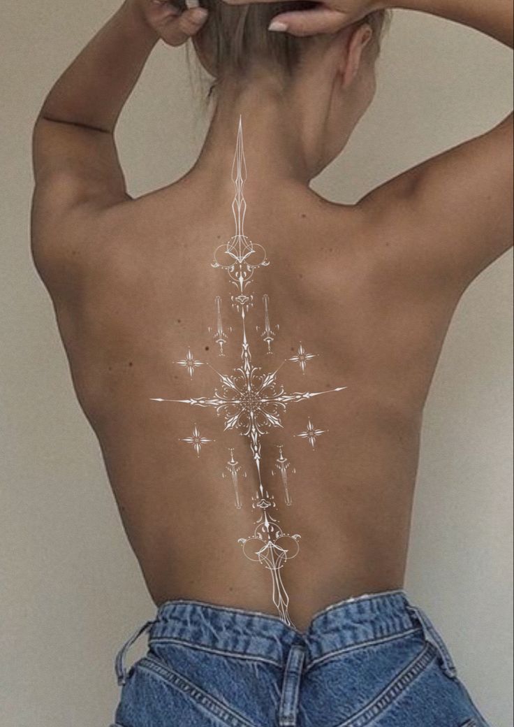 the back of a woman's body with an intricate design on her lower back