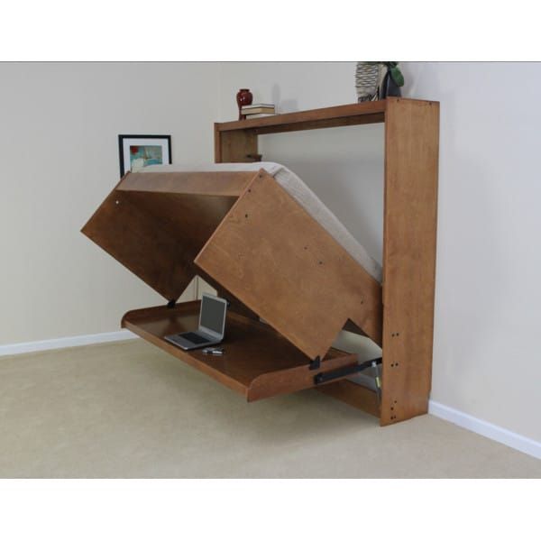 an open laptop computer sitting on top of a wooden shelf next to a white wall