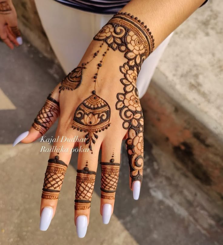 a woman's hand with henna tattoos on it