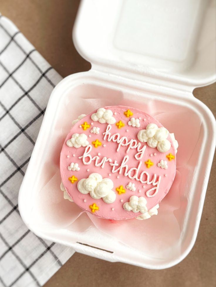 a pink birthday cake in a foam container with the words happy birthday written on it