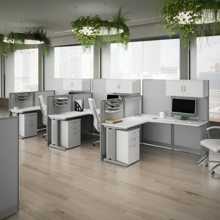 an office cubicle with desks, chairs and plants hanging from the ceiling